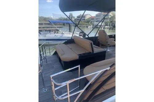 Slide: The Image of 2026 Godfrey Sweetwater 2286 SFL pontoon boat with tan seating, docked in a marina. - 3