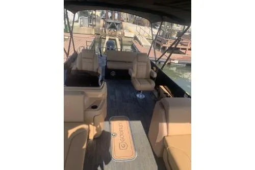 Slide: The Image of 2026 Godfrey Sweetwater 2286 SFL pontoon boat interior with tan seating and shaded deck. - 7