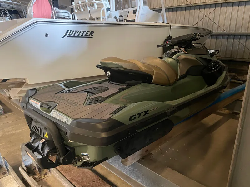 Slide: The Image of 2023 Sea-Doo GTX Limited 300 jet ski in storage, next to a boat. - 12