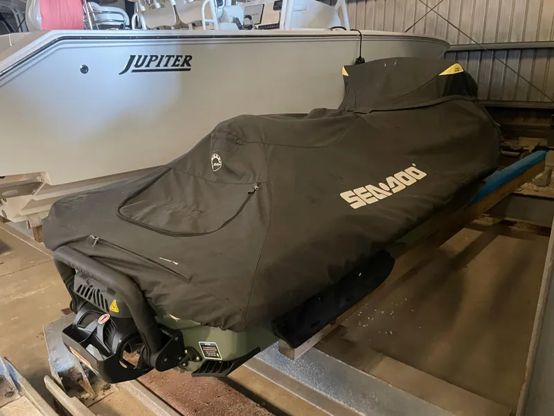 Slide: The Image of 2023 Sea-Doo GTX Limited 300 covered, stored indoors beside a boat. - 16