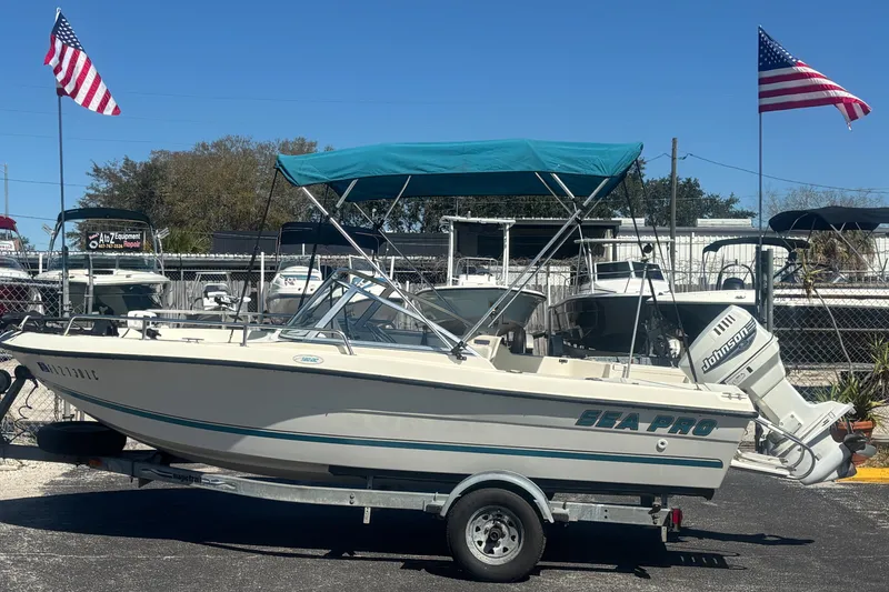 Slide: The Image of 2000 Sea Pro 180 Dual Console boat with Johnson outboard motor and blue canopy. - 0