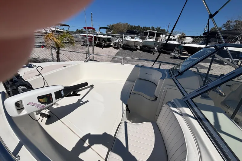 Slide: The Image of 2000 Sea Pro 180 Dual Console boat interior with seating and motor, parked in a marina. - 11