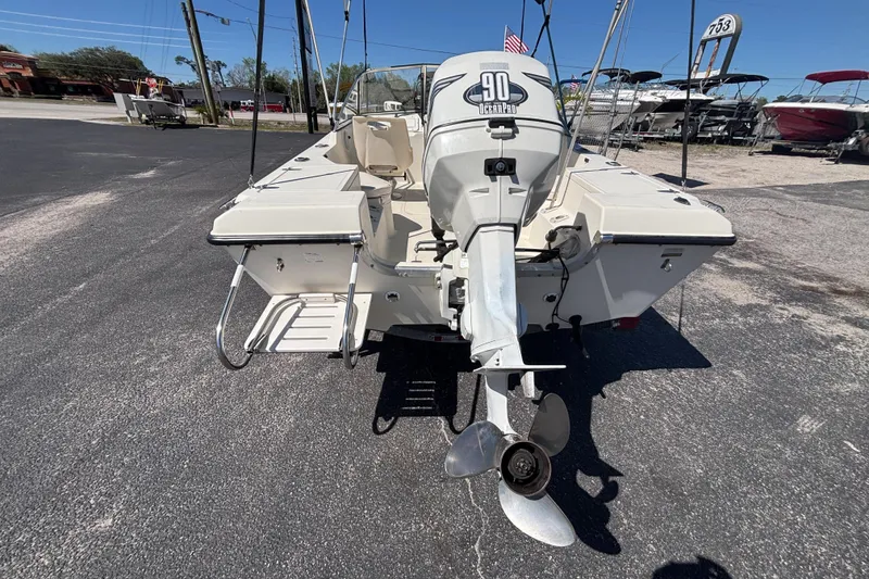 Slide: The Image of 2000 Sea Pro 180 Dual Console boat with outboard motor, parked on asphalt. - 14