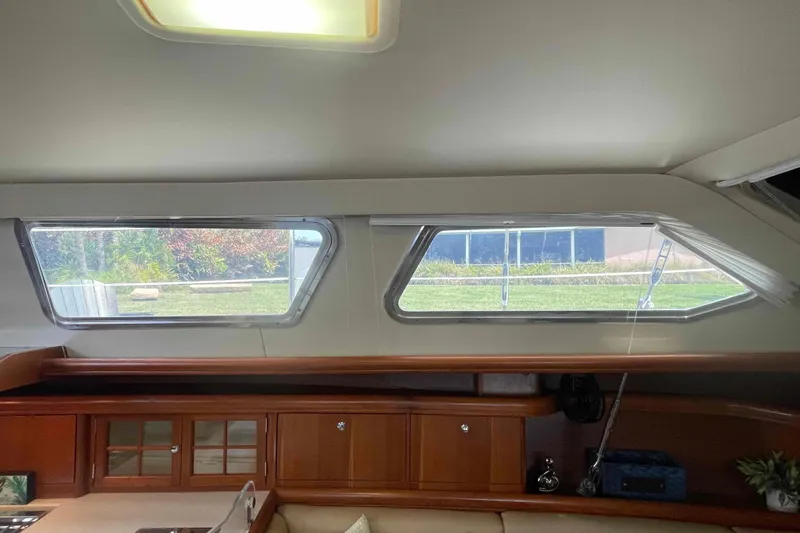 Slide: The Image of Interior view of 2003 Hunter 426 Deck Salon with large windows and wooden cabinetry. - 102