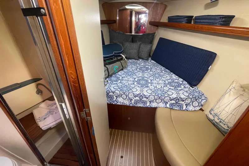 Slide: The Image of Cozy cabin interior of 2003 Hunter 426 Deck Salon with patterned bedding and wooden accents. - 11