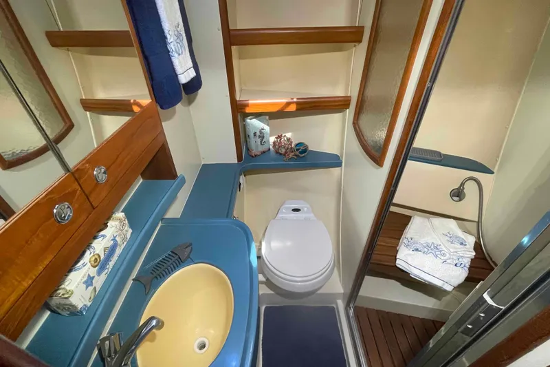 Slide: The Image of 2003 Hunter 426 Deck Salon bathroom with sink, toilet, and shower area. - 12