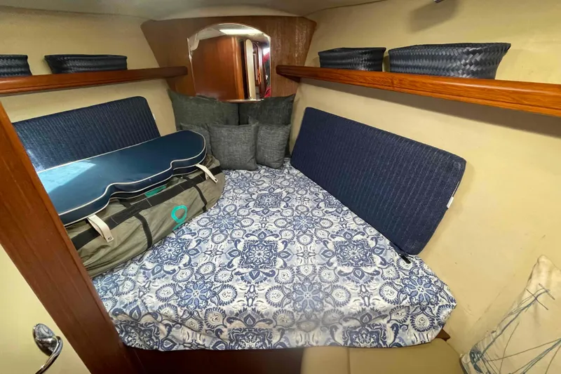 Slide: The Image of Cozy cabin interior of 2003 Hunter 426 Deck Salon with patterned bedding and storage baskets. - 13