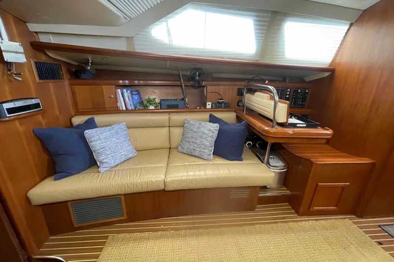 Slide: The Image of Interior of 2003 Hunter 426 Deck Salon with beige seating and navigation station. - 19