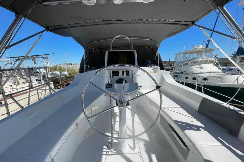 Slide: The Image of 2003 Hunter 426 Deck Salon yacht cockpit with steering wheel, docked in marina. - 2