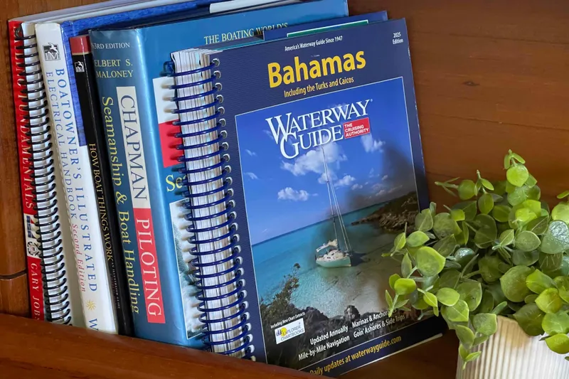 Slide: The Image of Books on boating and navigation, including "Waterway Guide Bahamas," beside a plant. - 20