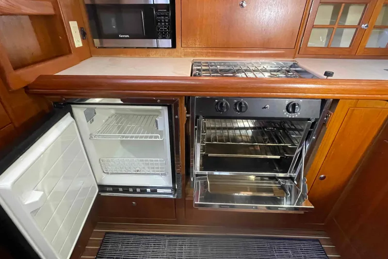 Slide: The Image of 2003 Hunter 426 Deck Salon kitchen with fridge, oven, and microwave. - 22