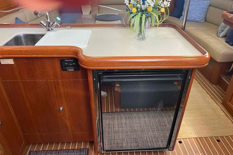 Slide: The Image of Luxurious 2003 Hunter 426 Deck Salon interior with kitchenette and floral centerpiece. - 27