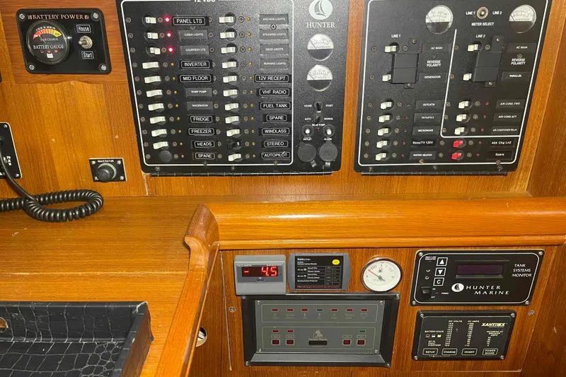 Slide: The Image of Control panel of a 2003 Hunter 426 Deck Salon yacht with various switches and gauges. - 34