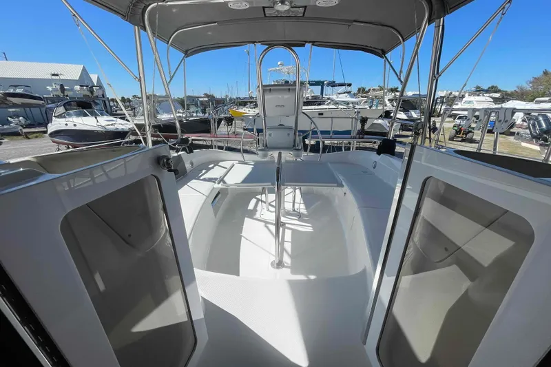 Slide: The Image of 2003 Hunter 426 Deck Salon sailboat cockpit with canopy, docked among other boats. - 41