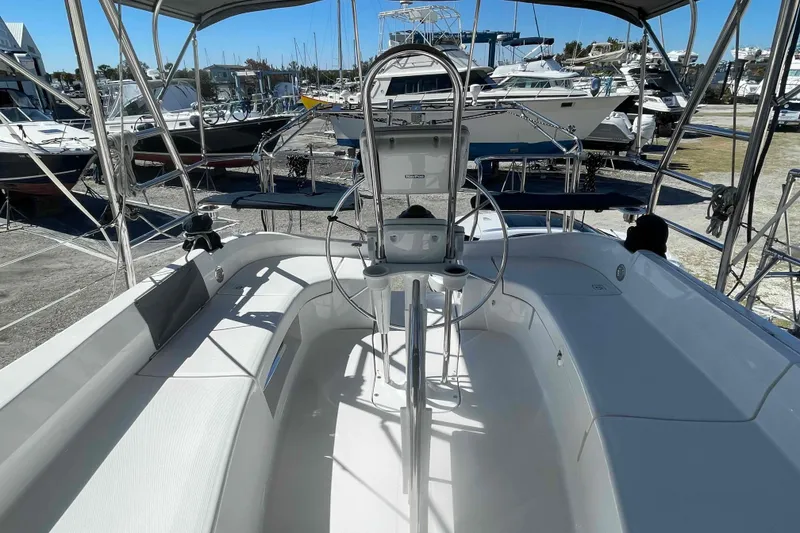 Slide: The Image of 2003 Hunter 426 Deck Salon sailboat cockpit with steering wheel, docked among other boats. - 42