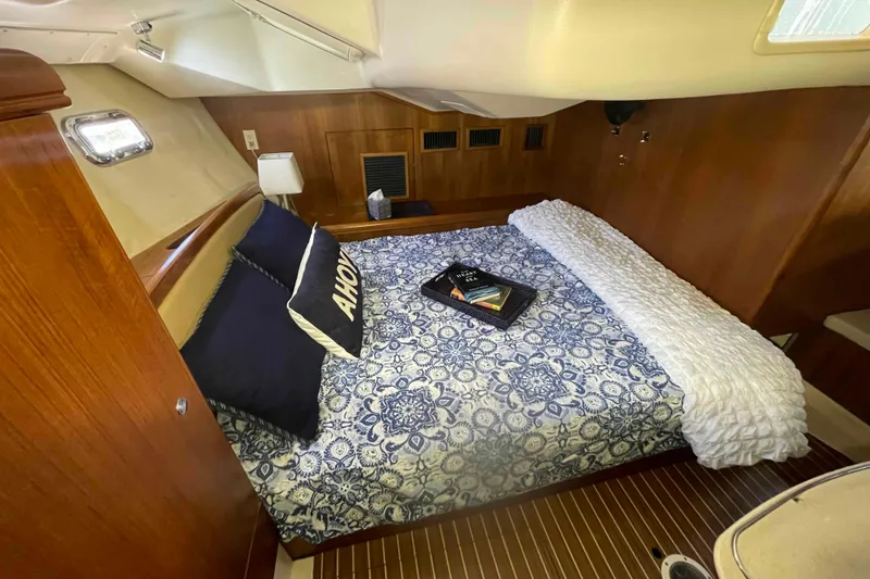 Slide: The Image of Cozy cabin interior of 2003 Hunter 426 Deck Salon with nautical bedding and wood paneling. - 6