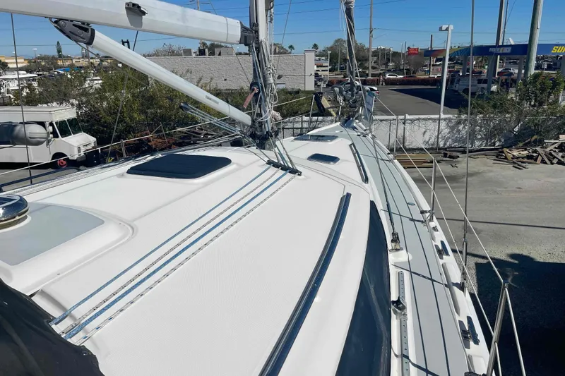 Slide: The Image of 2003 Hunter 426 Deck Salon sailboat, docked, showcasing sleek deck and rigging. - 65