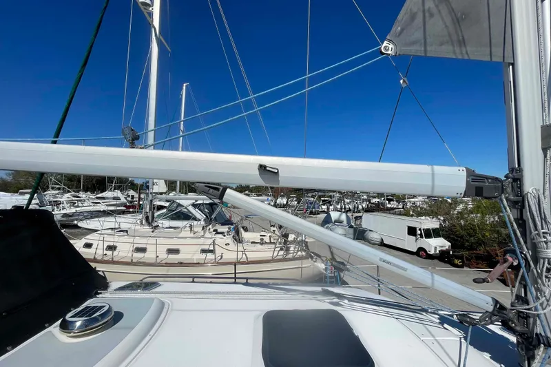 Slide: The Image of 2003 Hunter 426 Deck Salon sailboat docked, surrounded by other boats under a clear blue sky. - 66