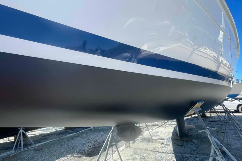 Slide: The Image of 2003 Hunter 426 Deck Salon sailboat hull on stands, blue and white design. - 86