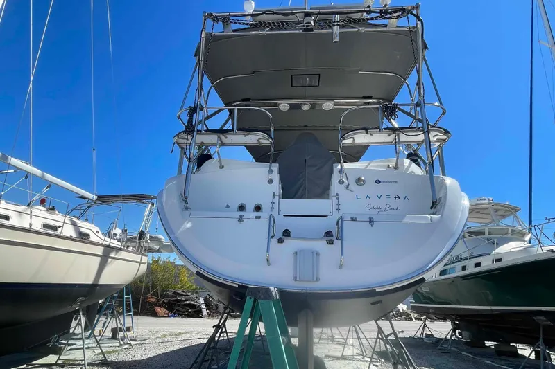 Slide: The Image of Hunter 426 Deck Salon 2003 sailboat on stands, viewed from the stern, under clear blue sky. - 87