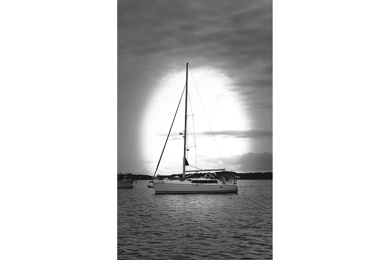 Slide: The Image of Sailboat Hunter 426 Deck Salon 2003 on calm water at sunset, black and white. - 89