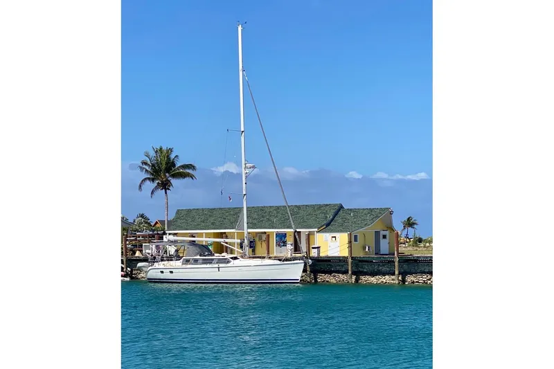 Slide: The Image of Sailboat Hunter 426 Deck Salon 2003 docked by a tropical house with palm trees. - 91
