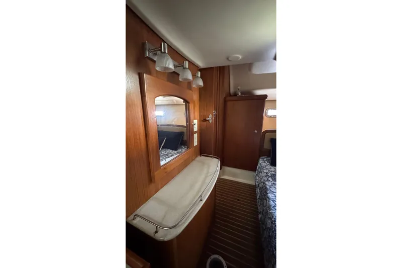 Slide: The Image of Interior of 2003 Hunter 426 Deck Salon with wooden cabinetry and mirror. - 98