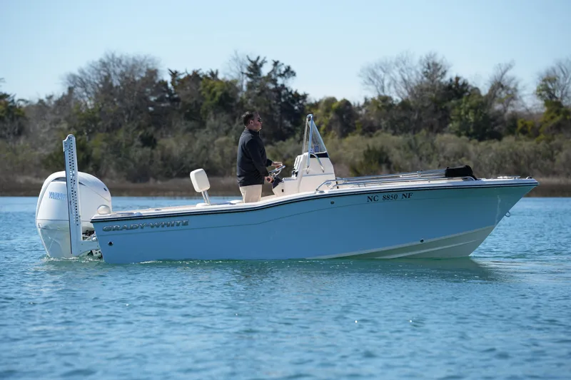 Slide: The Image of 2025 Grady-White Fisherman 180 boat on calm water, with a person steering. - 10