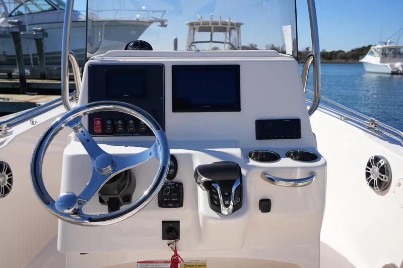 Slide: The Image of 2025 Grady-White Fisherman 180 boat console with steering wheel and navigation screens. - 19