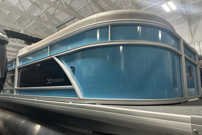 Slide: The Image of 2026 Godfrey EX 2286 SFLX pontoon boat in showroom, featuring sleek blue design. - 3