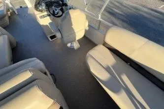 Slide: The Image of 2017 Sun Tracker Party Barge 24 DLX interior with beige seating and steering console. - 4