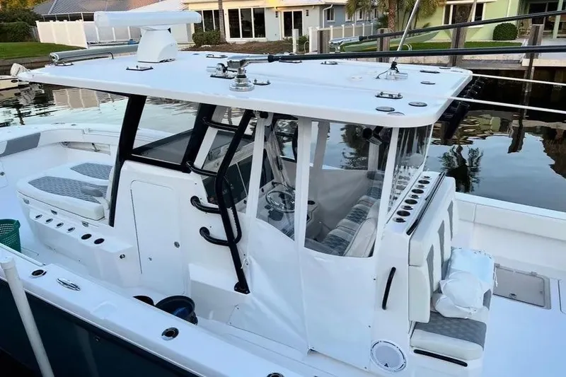 Slide: The Image of 2022 Invincible 35 Catamaran with sleek design, docked by waterfront homes. - 4