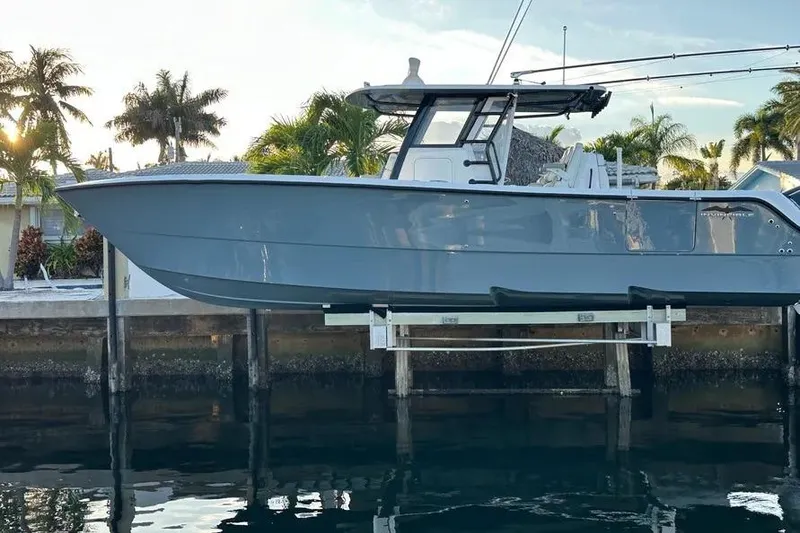 Slide: The Image of 2022 Invincible 35 Catamaran docked, surrounded by palm trees and waterfront homes. - 7