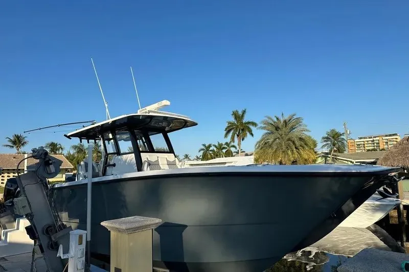 Slide: The Image of 2022 Invincible 35 Catamaran docked, surrounded by palm trees under clear blue sky. - 8