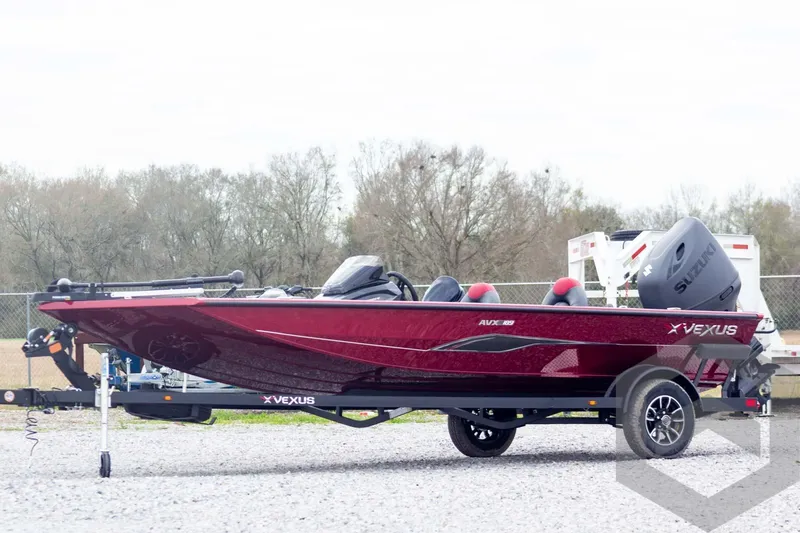 Slide: The Image of 2026 Vexus Defender 189 boat in red, parked on a trailer, outdoors. - 1