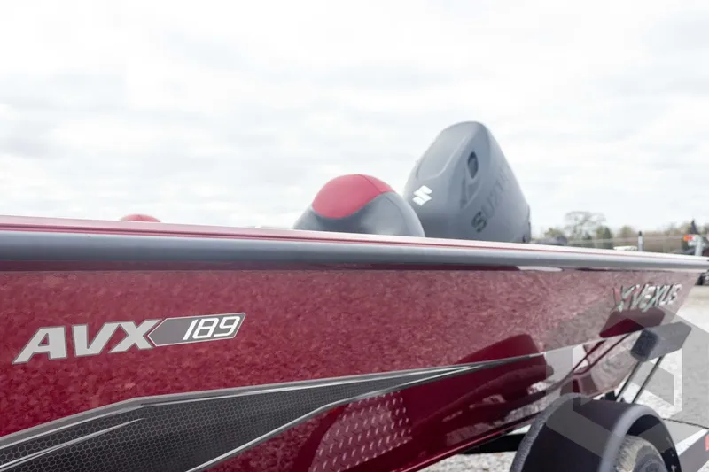 Slide: The Image of 2026 Vexus Defender 189 boat, red exterior, AVX 189 model, parked outdoors. - 19