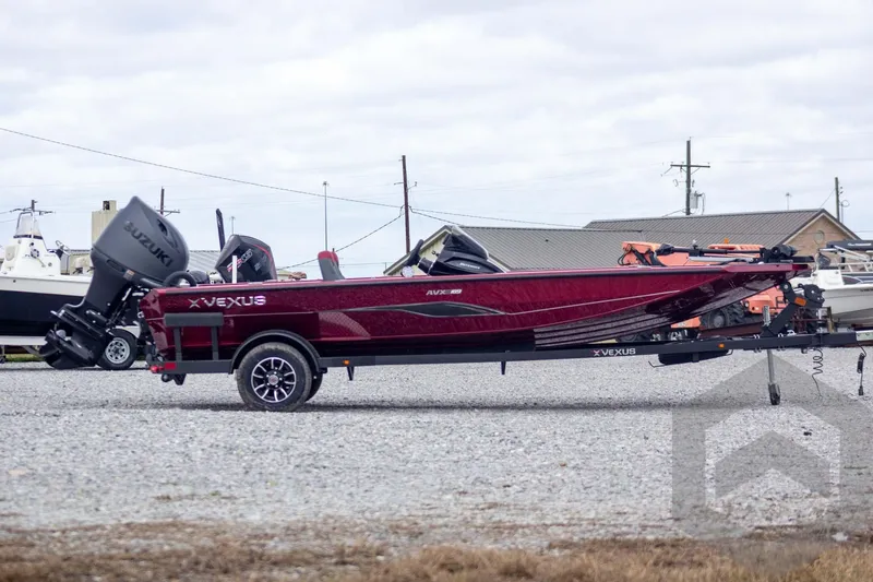 Slide: The Image of 2026 Vexus Defender 189 boat with Suzuki engine on trailer, parked outdoors. - 2