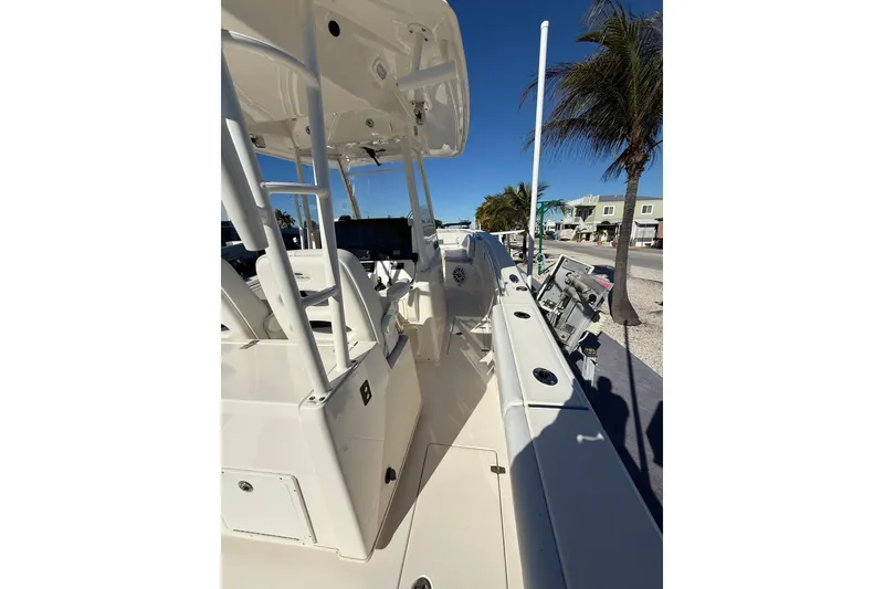 Slide: The Image of 2022 Cobia 320 Center Console boat, docked with palm trees in the background. - 11