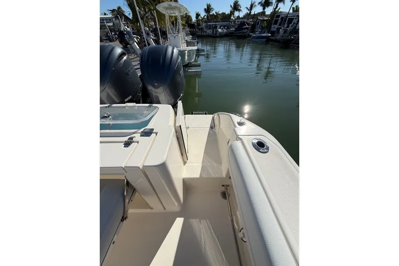 Slide: The Image of 2022 Cobia 320 Center Console boat docked, featuring dual engines and sleek design. - 12