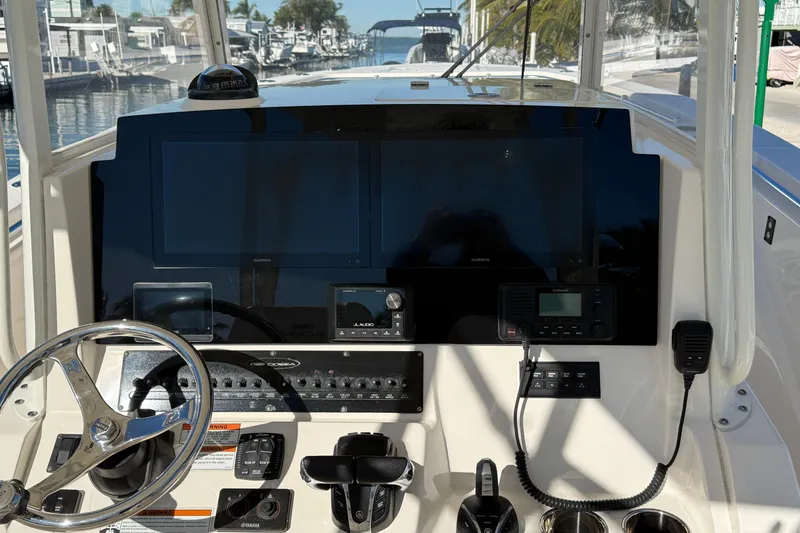 Slide: The Image of 2022 Cobia 320 Center Console dashboard with steering wheel and navigation controls. - 14