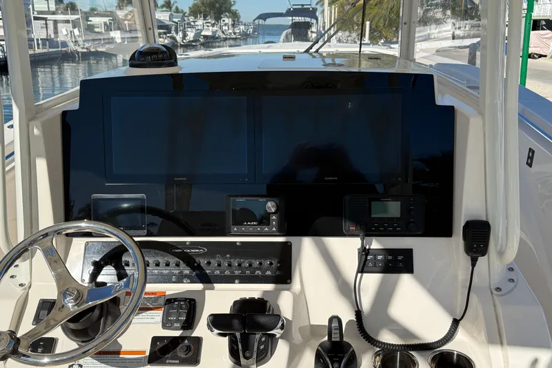 Slide: The Image of 2022 Cobia 320 Center Console dashboard with steering wheel, navigation screens, and controls. - 15
