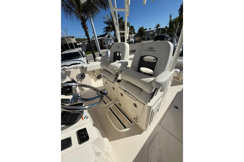 Slide: The Image of 2022 Cobia 320 Center Console boat interior with helm seats and steering wheel. - 29