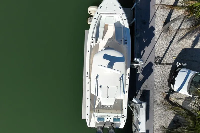 Slide: The Image of Aerial view of 2022 Cobia 320 Center Console boat docked by the water. - 6