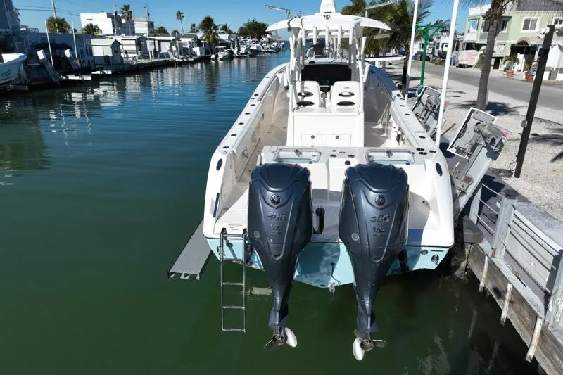 Slide: The Image of 2022 Cobia 320 Center Console boat docked with dual outboard engines. - 7