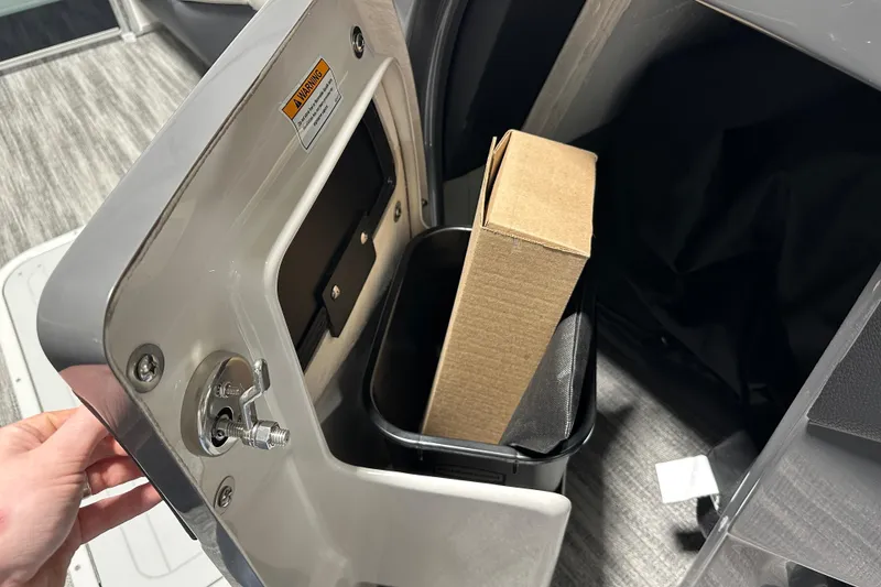 Slide: The Image of Hand opening storage compartment on 2026 Godfrey MC 235 SBC boat interior. - 12