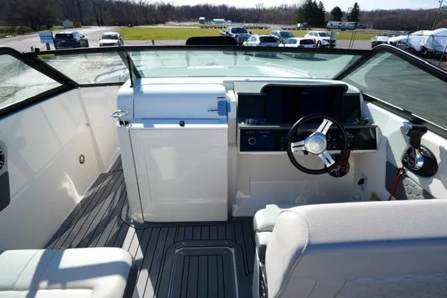 Slide: The Image of 2021 Sea Ray SDX 250 boat interior with steering wheel and seating area. - 12