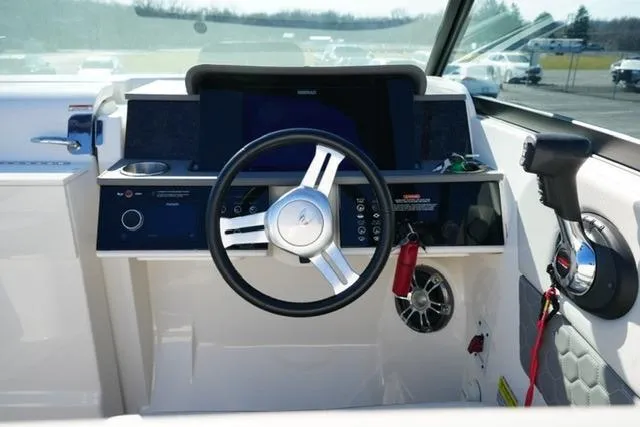 Slide: The Image of 2021 Sea Ray SDX 250 helm with steering wheel and control panel. - 13