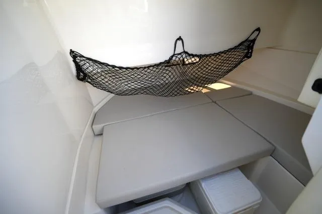 Slide: The Image of 2021 Sea Ray SDX 250 interior cabin with cushioned seating and storage net. - 18