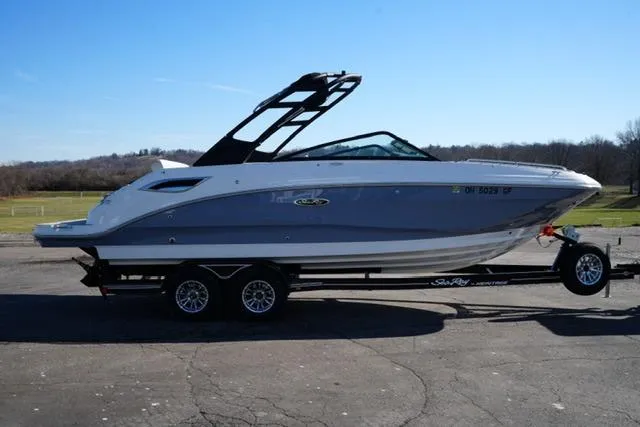 Slide: The Image of 2021 Sea Ray SDX 250 boat on trailer, parked outdoors under clear blue sky. - 4