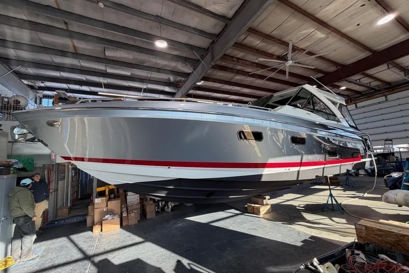 Slide: The Image of 2017 Formula 430 Super Sport Crossover boat in a warehouse, elevated on stands. - 8